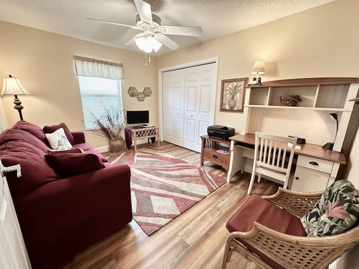 Dhomë gjumi për vizitorët me divan dhe tavolinë pune/printer