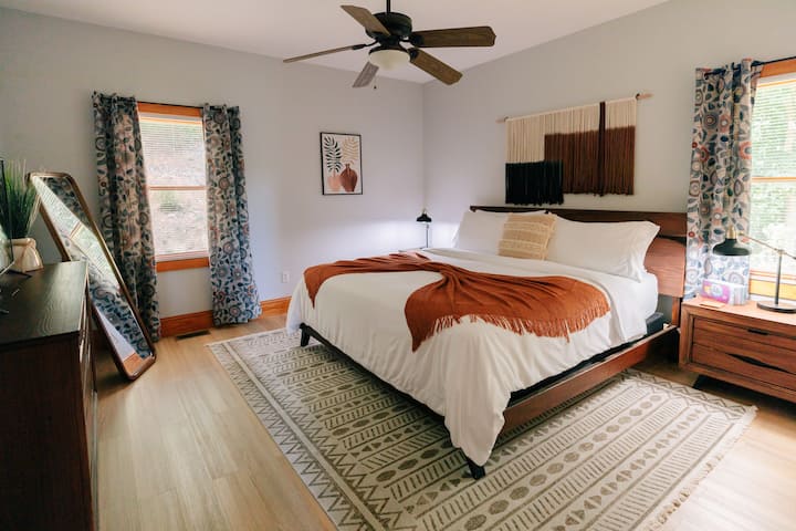 Მთავარი სართულის საძინებელი №1 დიდი ზომის საწოლით, ტელევიზორითა და სრული ზომის სარკით.