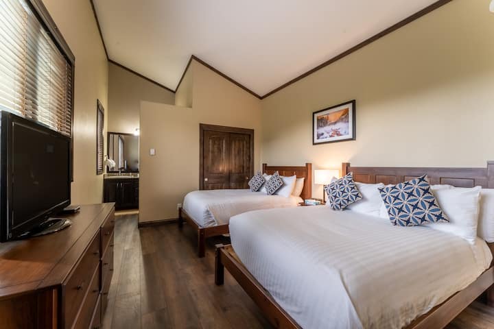 Spálňa pre hostí s dvoma plnohodnotnými posteľami, televízorom s plochou obrazovkou a vlastnou kúpeľňou. 