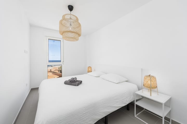 Dormitorio con cama doble y vistas al mar