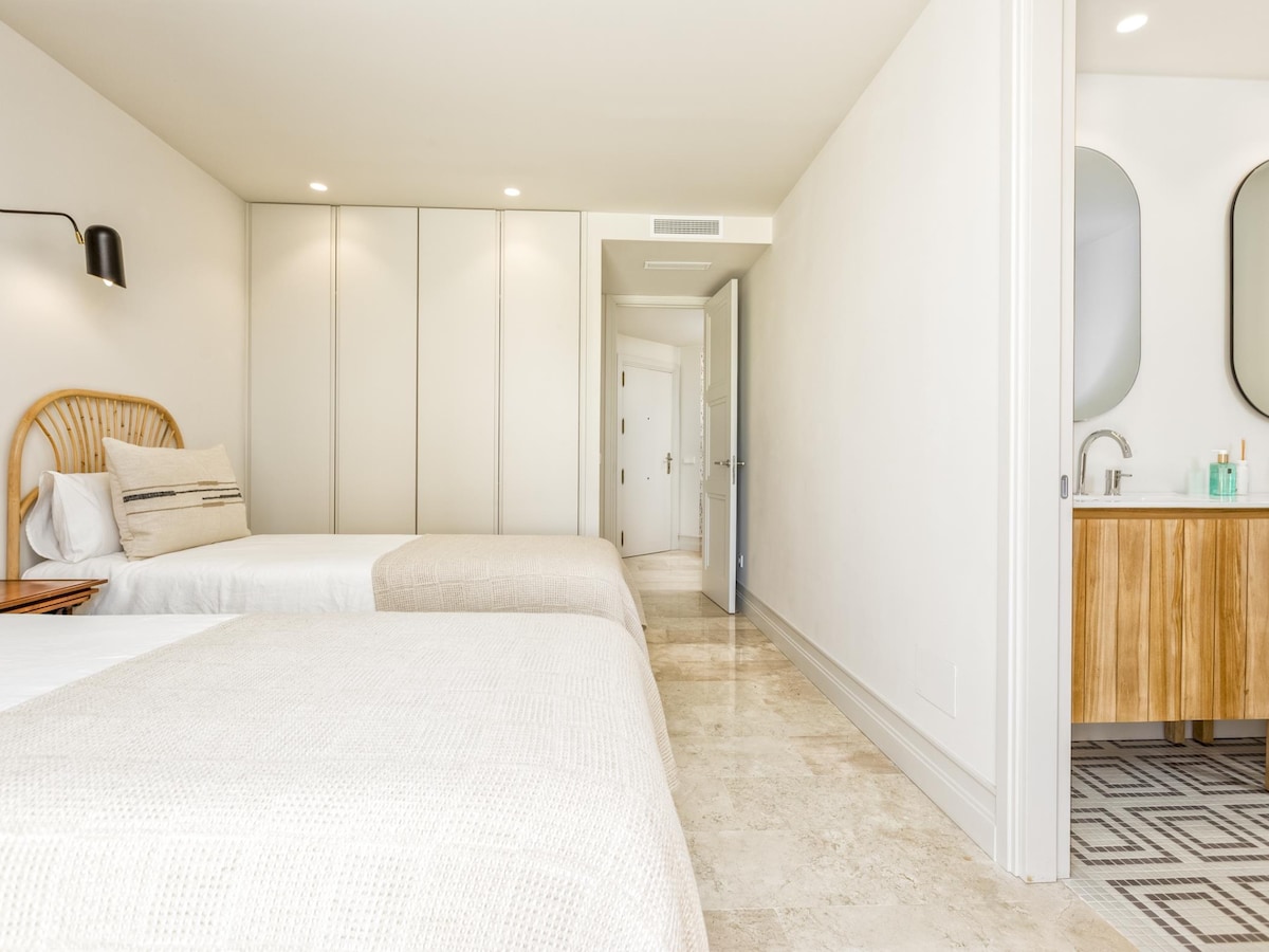 Twin bedroom detail at Terraza Del Sol — rattan headboard, waffle throw