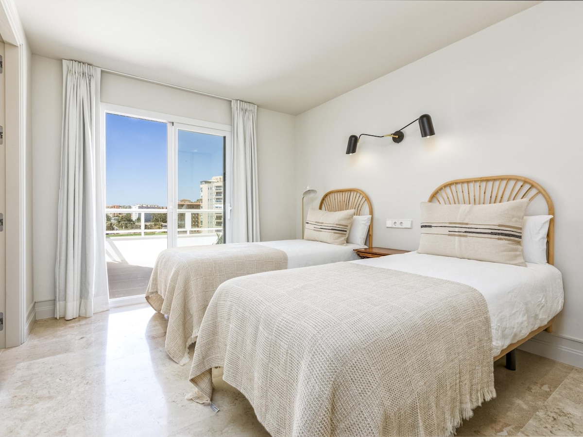 Twin bedroom at Terraza Del Sol — two single beds, rattan headboards, terrace view
