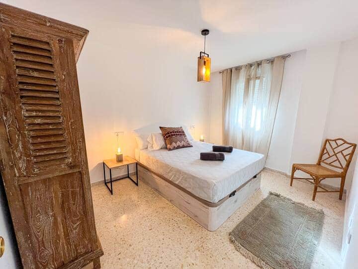 Habitación doble con cama de 160cm. Dispone de dos mesillas de noche, dos lámparas pequeñas sobre ellas. Silla de madera. Alfombra. Y un armario de madera maciza antiguo. 