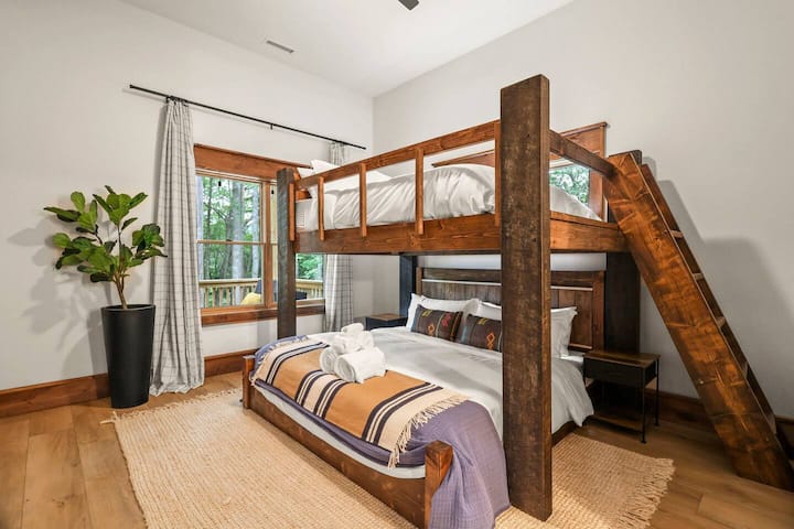 This custom queen-over-king bunk is large enough for a group of 4. The upper bunk can hold up to 500 lbs. 