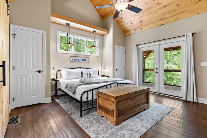 חדר שינה ראשי מרווח עם דלתות למרפסת הסגורה.