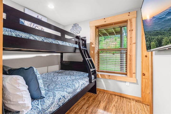 La chambre superposée en bas a des lits jumeaux sur des lits doubles, un havre de paix adapté aux enfants avec une salle de bain attenante et une télévision intelligente, offrant un espace privé pour que les jeunes voyageurs se détendent après une journée d'aventure. C'est l'endroit idéal pour les histoires du soir ou les dessins animés du matin.
