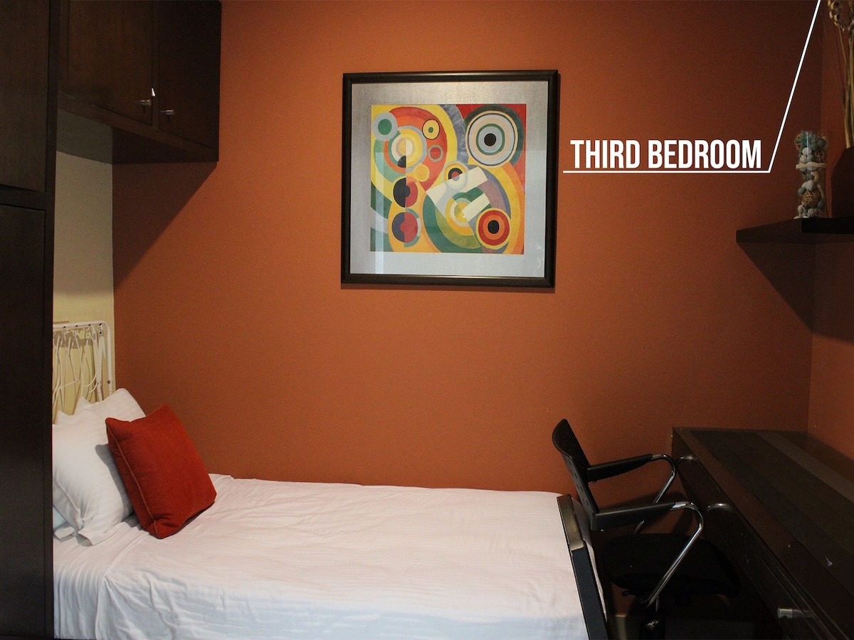 Tercer dormitorio con un diseño acogedor, una cómoda grande y acceso al balcón, que ofrece un refugio privado con vistas a la ciudad.