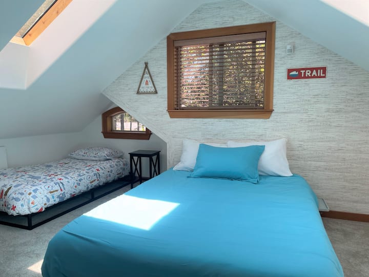 2階のファミリースタイルの寝室には、クイーンサイズベッド1台とシングルベッド2台、バスルームが付いています。