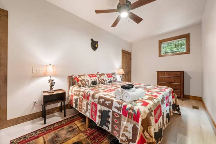 Dormitorio de osos con cama tamaño king y vestidor. Vistas a las maderas está detrás de la casa.