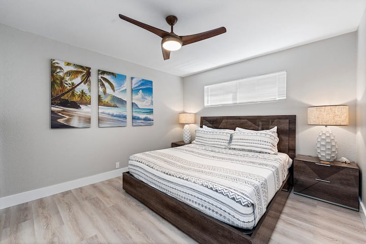 Downstairs Junior primary with king bed and vibrant island artwork.