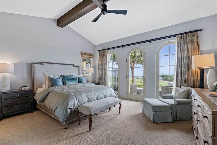 Dormitorio principal con vistas panorámicas al campo de golf y al horizonte del océano Pacífico