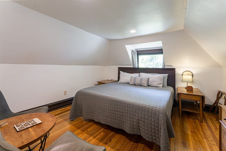 Dormitorio n.º 6 (segundo piso) con una cama tamaño king y un baño completo compartido con la habitación n.º 5. Se accede al baño a través de un pasillo corto, privado para las habitaciones 5 y 6.