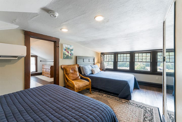 El dormitorio del tercer piso con dos camas tamaño queen y un baño en suite. Ten en cuenta la altura del techo más baja, ¡recomiendo otra habitación para huéspedes más altos!