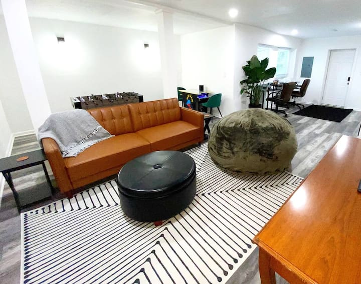 غرفة معيشة مع ممر باكمان وكرة القدم وتلفزيون 58بوصة ونوم أريكة ومساحة مكتبية في الطابق السفلي.