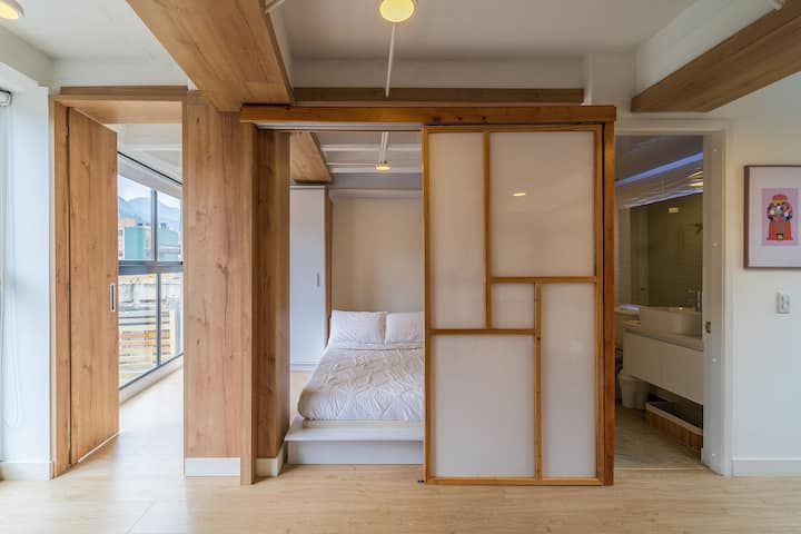 宽敞舒适的床，位于私人空间，配有日式滑动门，为卧室增添了一丝优雅和隐私。