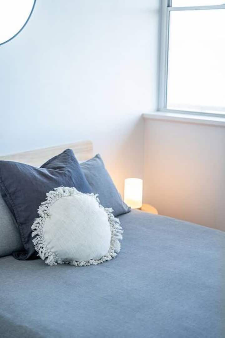 Les coussins texturés, l'éclairage chaud et les tons neutres créent un espace apaisant pour se détendre.