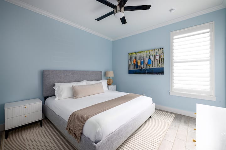 Quarto de hóspedes com cama king e decoração costeira relaxante.