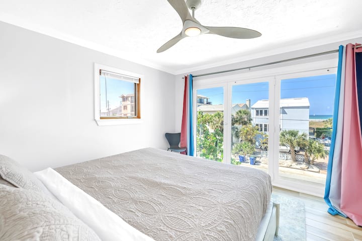 Събудете се с изглед към залива от тази светла и просторна спалня с прозорци от пода до тавана.