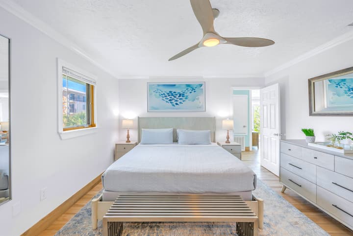 Удобна главна спалня с голямо двойно легло, вентилатор на тавана и интериор в морски стил.