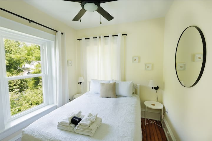 Queen bedroom with curtains and bedside lights for enjoying a book in the evening after a day at the beach.