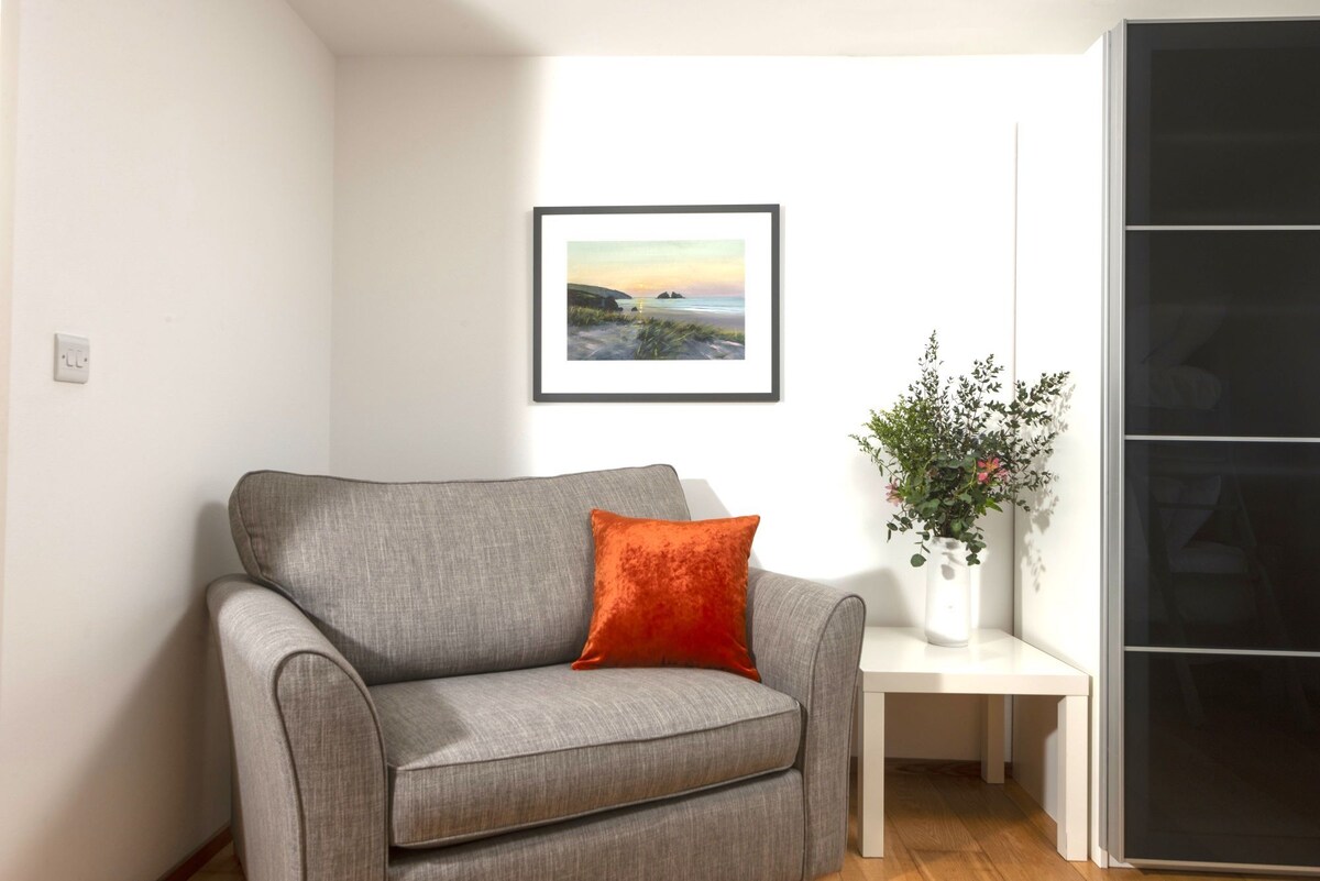 Chair with colourful picture behind it and table - Treheyl