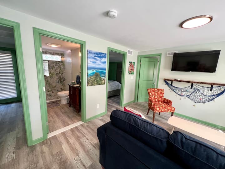 غرفة معيشة بها سبليت صغير فعال للتكييف والتدفئة وتلفزيون ذكي