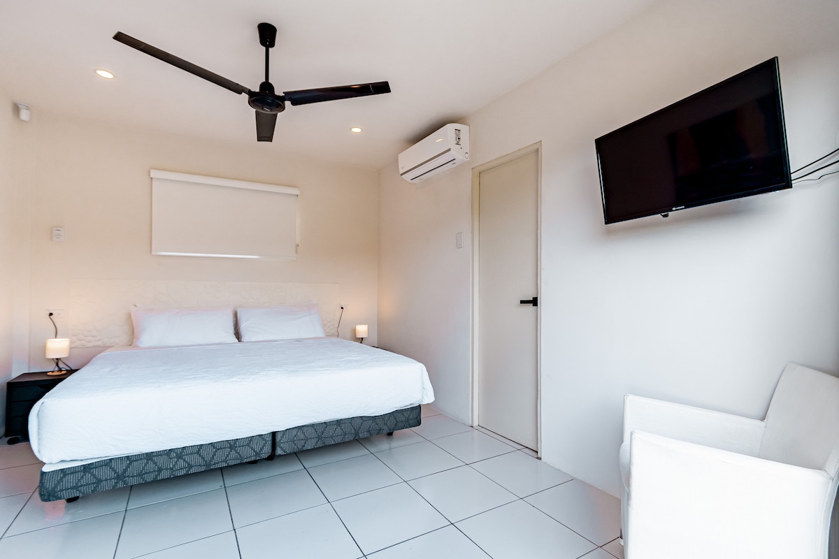 ห้องนอนดีลักซ์ของบ้านในซานตาครูซ อารูบา - เตียงคิงไซส์เต็มรูปแบบ - ที่พักผ่อนที่อบอุ่นพร้อมเตียงนุ่มสบาย เหมาะสำหรับการพักผ่อน - ทีวี - แสงสว่างนุ่มนวลสำหรับอารมณ์ที่สงบ