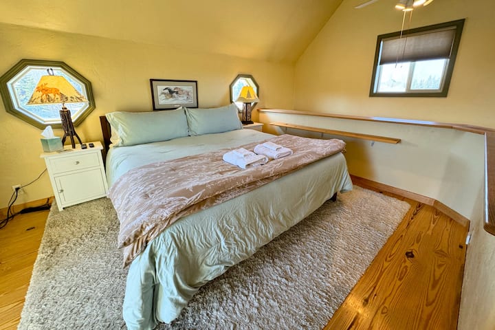 En la planta superior hay una cama tamaño king, un balcón frente a las montañas y un medio baño.
