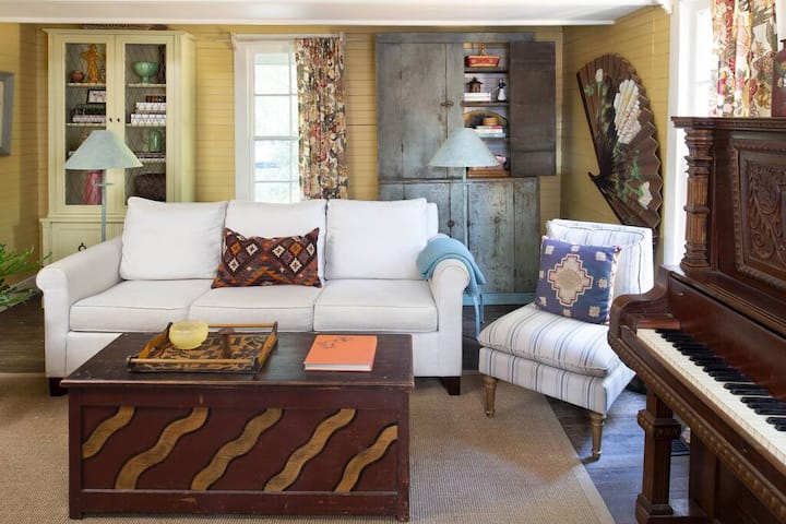 Cozy living room with books, puzzles, games and a piano.