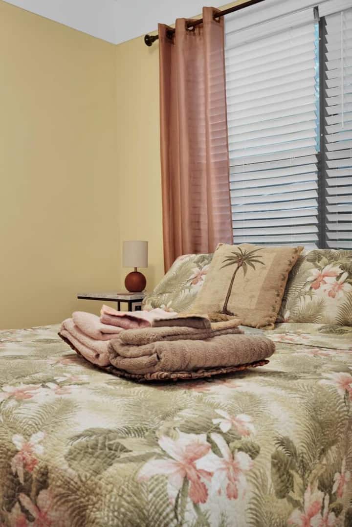 - Чисти спални комплекти, сгънати спретнато върху меко покривало с флорални мотиви   - Уютна спалня, която посреща гостите след забавните дни в Сейнт Огъстин   - Внимателно подбрани детайли подобряват това спокойно място за почивка