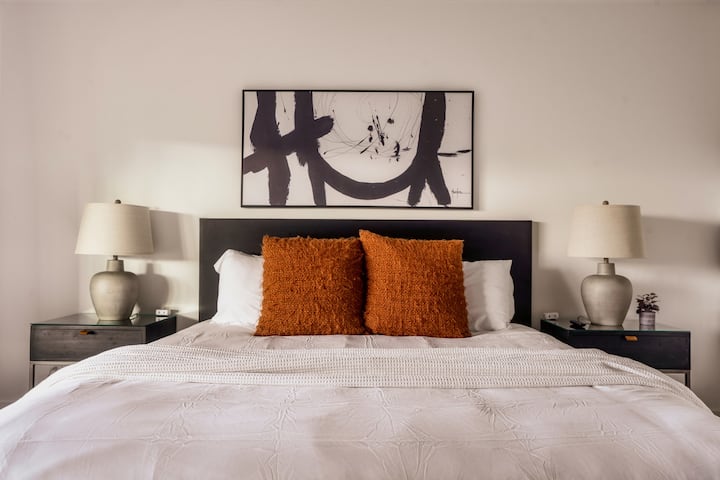 Chambre king size de niveau inférieur avec salle de bain attenante, cheminée, télévision et draps de luxe
