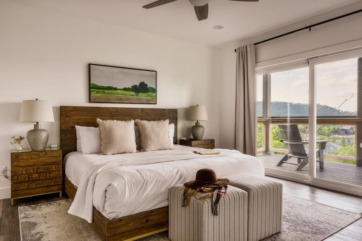 Chambre king size de niveau inférieur avec salle de bain attenante, cheminée, télévision et draps de luxe