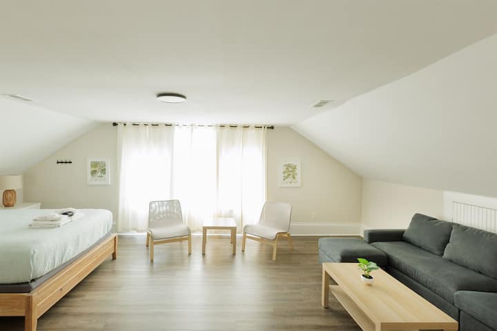 Chumba kikubwa cha kulala cha Queen chenye sebule ya ziada na televisheni.