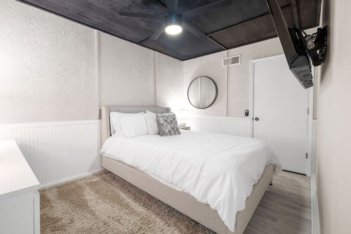 Un acogedor dormitorio tamaño queen de nivel inferior: comodidad tranquila para un refugio tranquilo.