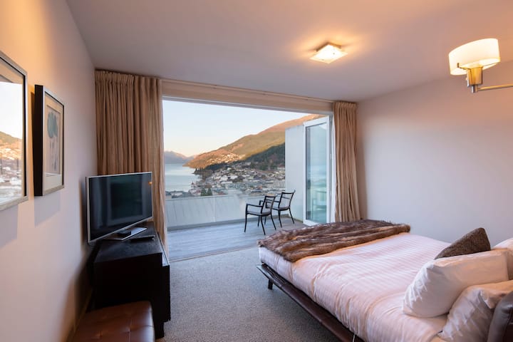 Segundo dormitorio tranquilo: acogedor y acogedor, este dormitorio cuenta con acceso a una terraza privada con impresionantes vistas al lago y a la montaña, perfecto para relajarse en la tranquilidad.