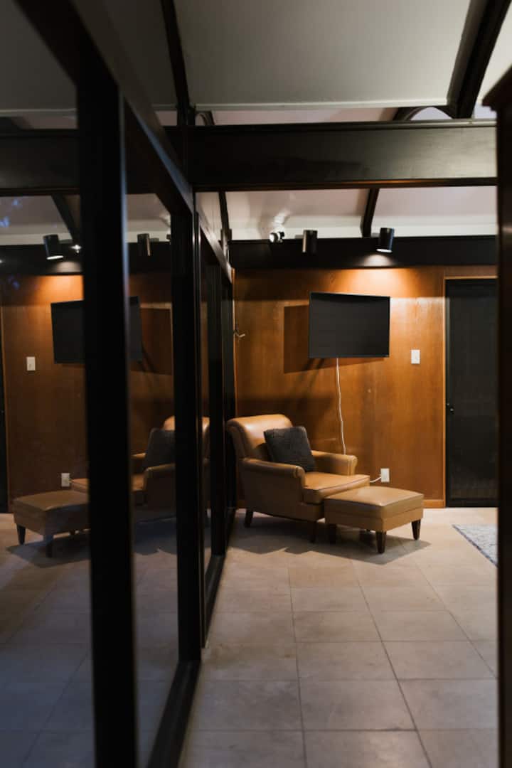 The large master bedroom has a smart-tv and a super comfy reading chair.