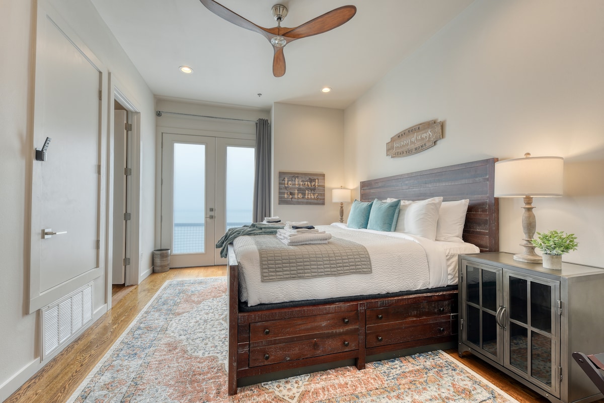 غرفة نوم علوية في الطابق الثالث مع شرفة جولييت وستائر داكنة لغرفة النوم