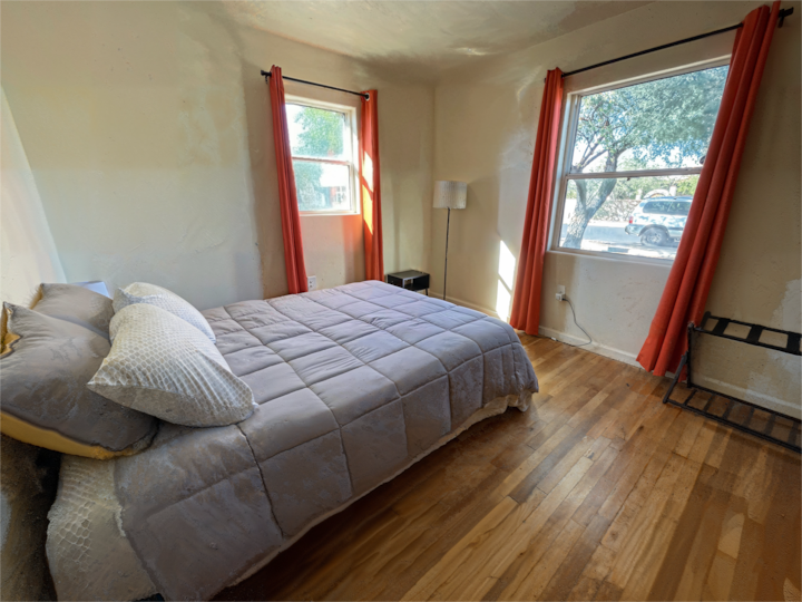 تحتوي غرفة النوم في مقدمة المنزل الرئيسي على سرير بحجم كوين ونوافذ على جانبين.