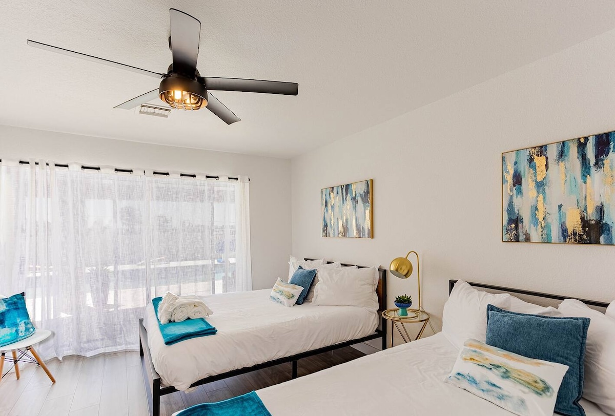 Nuestro dormitorio verde azulado con dos camas tamaño queen. Diseño ligero y contemporáneo con acceso directo a la piscina y al patio.