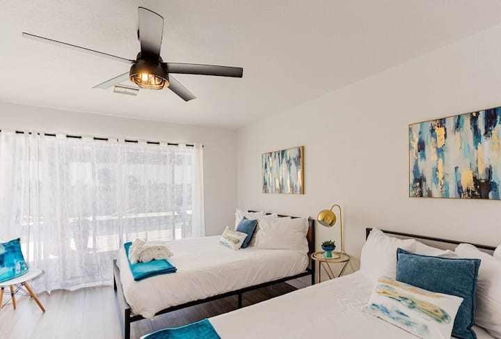 Our teal bedroom with two queen beds. Light and contemporary design with direct pool and patio access.