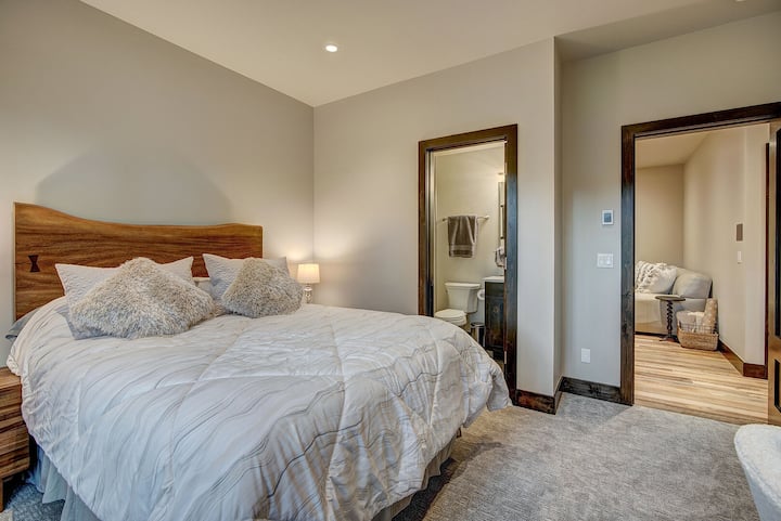 Спалня на приземното ниво с голямо двойно легло и баня със самостоятелна баня.