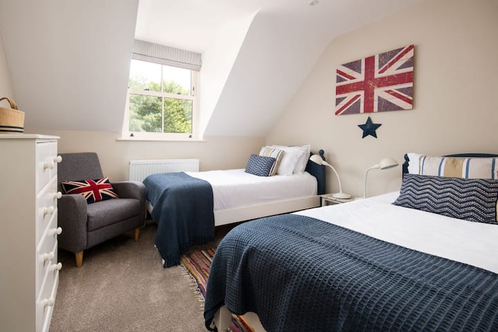 Partridge Lodge - четврта спална соба со два единечни кревета во целосна големина и поглед кон задните градини