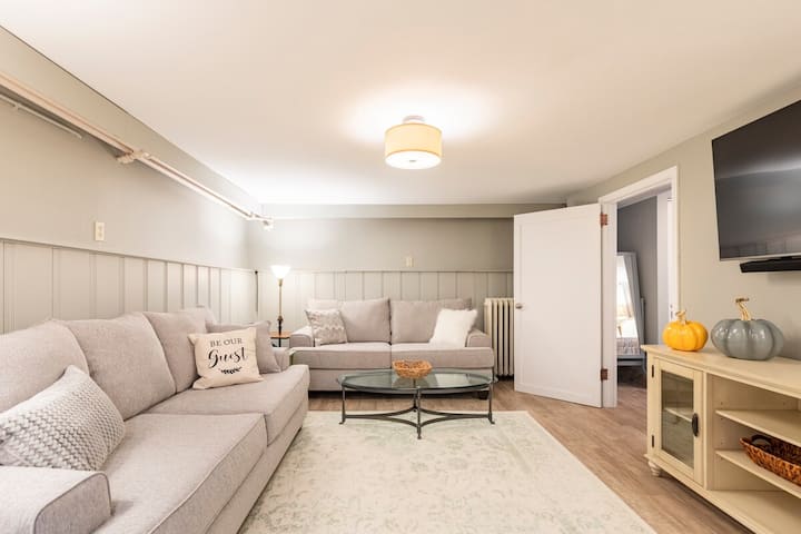 Sala familiar con sofá cama tamaño queen extraíble y televisión inteligente