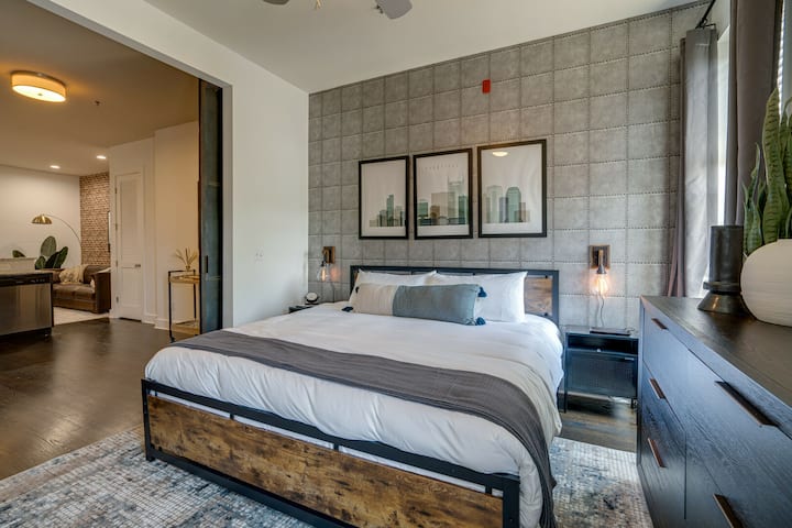 Chumba cha kulala cha Master kilicho na kitanda cha ukubwa wa King, fanicha za mbunifu na runinga ya skrini bapa.