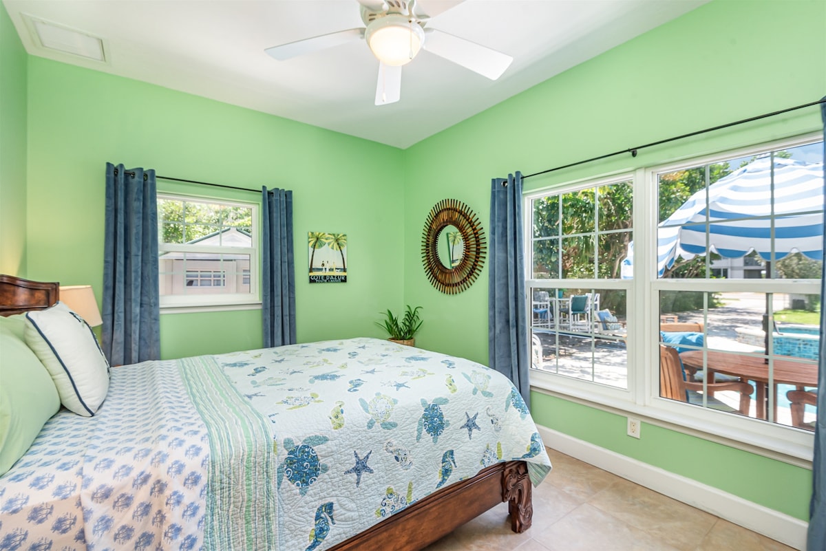 Slaapkamer met queensize bed en uitzicht op het zwembad 1e verdieping