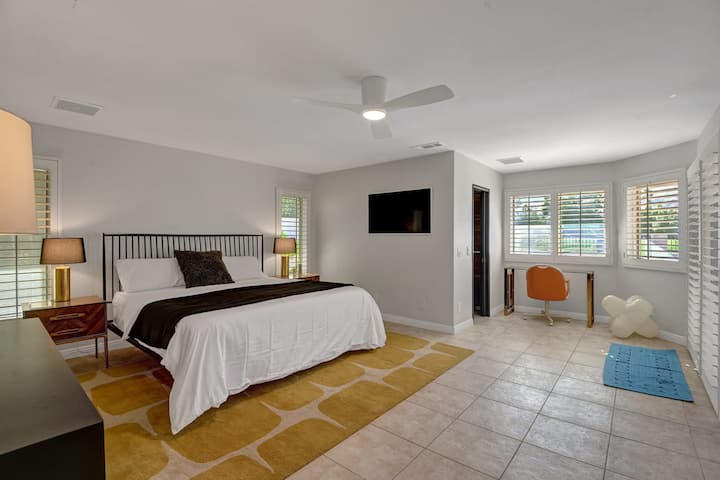 The main bedroom with a 43” Samsung Frame TV and a sliding door out to the pool.