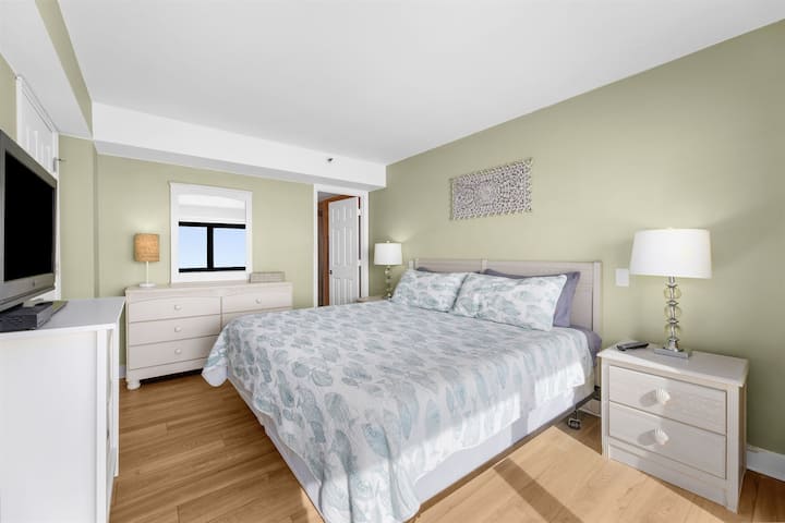 卧室区域配有加大双人床、枕头、床上用品和床单