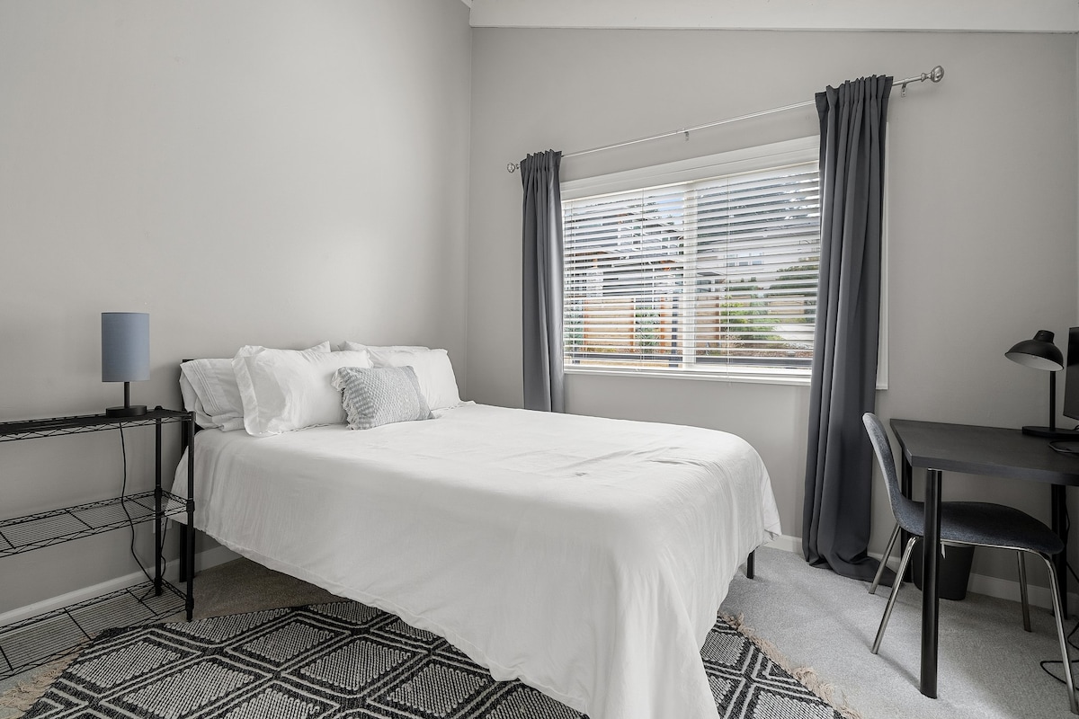 Plyšová manželská posteľ ponorená do množstva prirodzeného svetla.