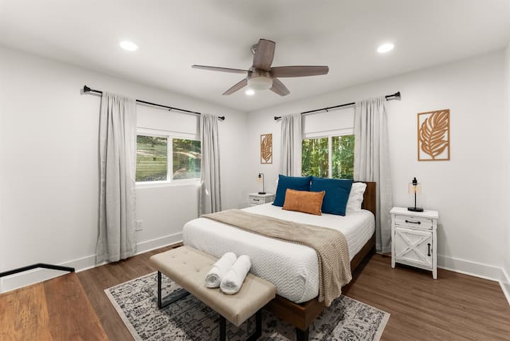 Second bedroom upstairs with queen bed and flat-screen TV.