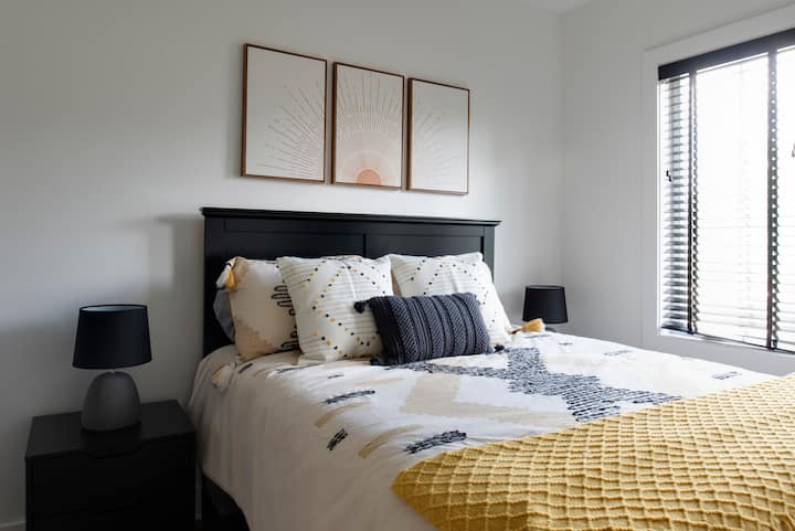 This bedroom offers queen size accommodations. Located at the top of the stairs, last door to the right. Enjoy double night stands, a 55 inch smart, TV, ceiling fan and personal closet. Private & relaxing. Overlooks the backyard. 